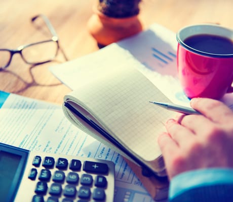 Paperwork, a calculator and a notepad on a desk