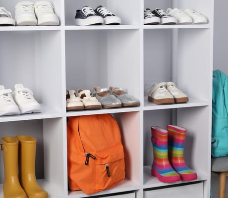 Children’s shoes, boots and bags on a shelf by the door