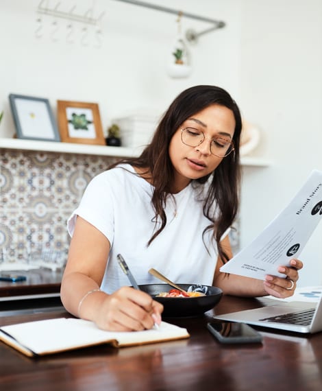 A parent working through documents at a kitchen table