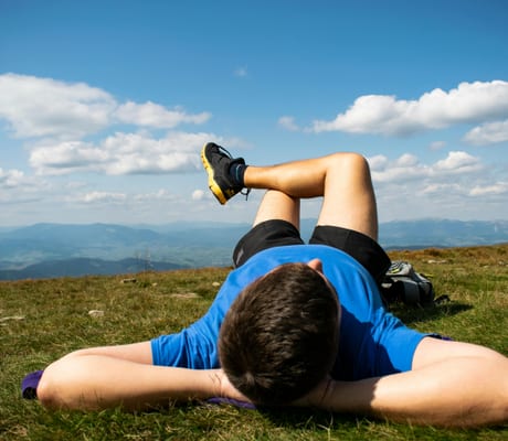 Someone lying on a hillside looking out at the view
